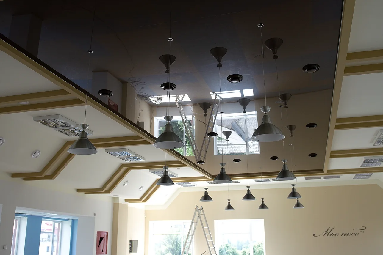 тёмный глянцевый потолок, много светильников